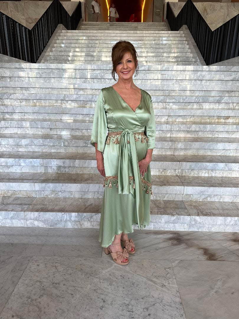 Woman in a green dress standing on a marble staircase
