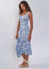 Woman wearing a blue floral dress against a white background